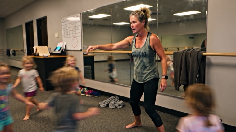 A studio owner mid-class, teaching young children